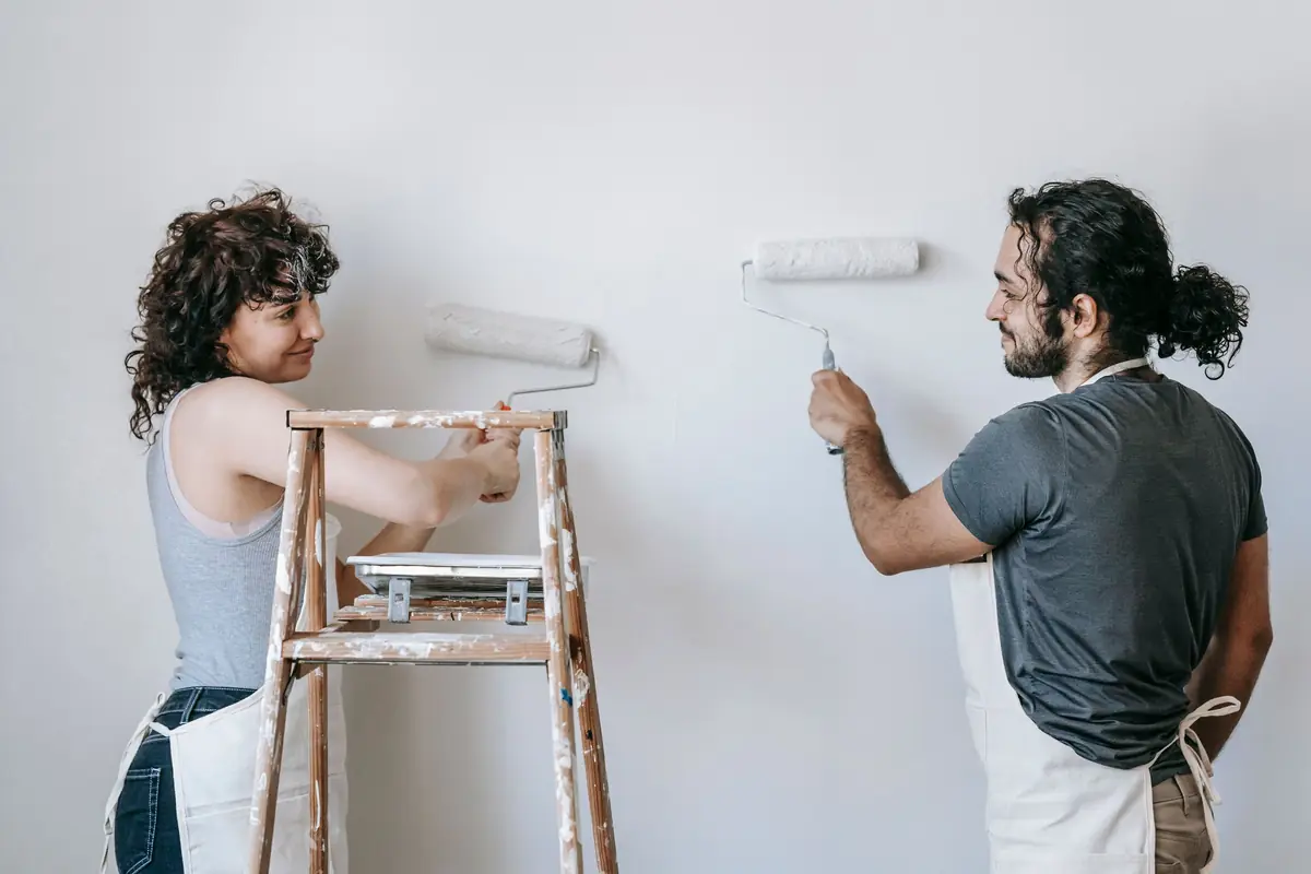 People painting a wall together — painting help in Greensboro